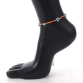 Detalle de tobillera bohemia de cuentas naranjas con flores azul claro en modelo negro - Estilo de Tobillera Naranja (0631)