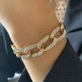 Gouden hiphop Cubaanse schakelarmband met fonkelende kristallen gedragen over een pak - Armband (0922) / Gouden Armband