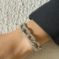 Zilverkleurige cubaanse schakelarmband met witte strass steentjes om de pols van model - Armband (0922) / Zilveren Armband