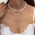 Collar minimalista de cuentas blancas con colgante de flor y corazón dorado en modelo - Collar