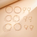Detailed close-up of six-pair gold earring set with pearls and star heart charms - Gold