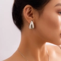 Minimalist silver teardrop earrings with a high-polish finish on a female model - Teardrop Stud Earrings (2951) / Silver