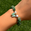 Dettaglio di un braccialetto di perline verdi con ciondolo a farfalla sul polso - Bracciale / Verde Giada