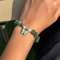 Vista dettagliata della collana con pietre verdi, perle bianche e un ciondolo a farfalla - Verde Giada