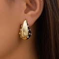 Gros plan d'une boucle d'oreille goutte d'or avec pierres scintillantes sur un modèle - Or Goutte d'Eau Avec Zirconia