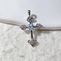 Macro shot of vintage silver cross pendant with light blue gemstone and white zircons - Silver With Blue Stone