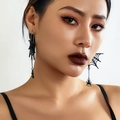 Close-up of black spider web earrings with dangling spider charms worn by a model - Black (3015)