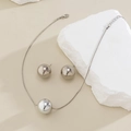 Minimalist silver snake chain necklace and round bead stud earrings set on stone props - Earrings And Necklace / Silver Tone