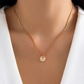 Close-up of minimalist gold initial C pendant necklace worn on a natural neck - Letter C - Gold