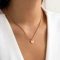 Detail of round gold pendant necklace featuring an engraved letter O on a square link chain - Letter M - Gold