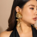 Gros plan détaillé des boucles d'oreilles pétales dorés avec texture métallique - 03 Boucles d'Oreilles Dorées