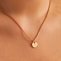 Minimalist gold necklace with a round pendant engraved with the letter A worn by a model - Letter A - Gold