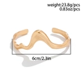Macro detail of wave-shaped golden metal choker with weight and diameter measurements - Wavy Open Bangle / Gold Bangle (02414)