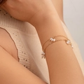 Bracelet double chaîne dorée orné de perles blanches porté délicatement au poignet - Bracelet Or (2400)