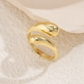 Detail of polished gold fluid teardrop open ring on textured stone pedestal - Gold (Ring)