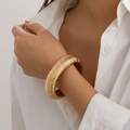 Minimalistische gouden geometrische manchetarmband met getextureerde horizontale groeven - Geribbelde Bangle (2450) / Goud