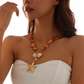 Close-up of golden starfish pendant and orange beaded seashell necklace on a model - Orange Necklace(6495)