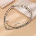 Macro detail of layered silver twist chain and rigid collar with white pearl and metal ball - Silver (5183)