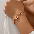 Close-up of rose gold Cuban link bracelet with a decorative round spring clasp on wrist - Gold (2464)