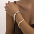 Detailopname van golvende onregelmatige open armbanden in goud en zilver op de pols - Golf Armband Set (5091) / Meerkleurig