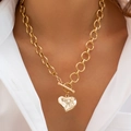 Dettaglio di una collana a catena dorata con ciondolo a cuore e chiusura a barra su modella - Collana Martellata Cuore - Oro