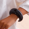 Detail of wide black acrylic cuff bracelet with high-gloss finish on female wrist - Dark Brown (2474)