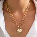 Detailopname van een gouden hartvormige punk ketting met OT-sluiting gedragen door model - Hart Stijl (6831) / Goud
