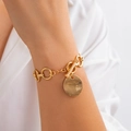Dettaglio macro del bracciale a catena dorata con ciondolo a moneta martellata e chiusura a T - Bracciale Martellato Tondo - Oro