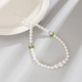 Detail of beaded phone strap featuring white faux pearls, purple tulips, and a bow charm - White + Purple