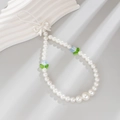 Detail of white faux pearl phone strap with blue tulips and a white bow charm - White+Blue