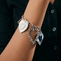 Detail of silver link bracelet with textured heart charms on model wearing a dark shirt - Bracelet-Silver (2925)