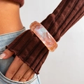 Detalle de brazalete ancho de resina rosa perlada sobre manga de punto fino - 04 Naranja 2656