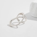 Close-up of a silver multi-layer intertwined ring on a white minimalist stone base - Silver Ring (0824)