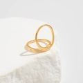 Detailed close-up of two minimalist gold wave bangles on white textured stone - Light Gold Ring (0823)