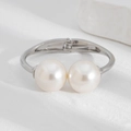 Detailed view of silver spring bracelet featuring two large glossy pearls on a white stone - 01 Double Large Pearl Open Bangle (2773) / Silver