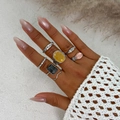 Detail of silver alloy ring set with yellow, black, and pink acrylic stones on model - Ring Set / Gold (6263)