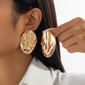 Detail of oversized irregular crumpled gold oval earrings worn by a female model - Irregular Wave Oval (3497) / Gold (3497)