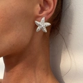 Detailed close-up of a silver starfish earring with white pearls on a model ear - Starfish Pearl (3532) / Silver