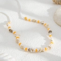 Detalle de la cadena corporal playera artesanal con conchas, perlas y estrellas de mar blancas - Naranja