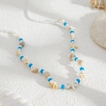 Detalle de cadena corporal con cuentas de arcilla azul, perlas blancas y conchas marinas - Azul