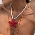 Primer plano del colgante de estrella de mar rosa con puntos dorados y cordón blanco - Collar Rojo Profundo (7105k1)
