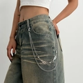 Detail of silver punk pant chain featuring thorn links and flame pendants on denim - 01 White K 1774