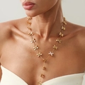 Dettaglio di una lunga collana a Y dorata con fiocchi in metallo e nappe di catena di perle - Fiocco Oro Catena Lunga a Y (7235)