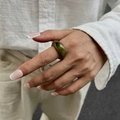 Nahaufnahme eines olivgrünen Harzrings mit Marmortexur am Zeigefinger für Damen - Light Coffee (0932)