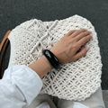 Close-up of a wide black resin bangle with a high-gloss finish worn on the wrist - Bangle / Black