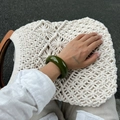 Macro shot of olive green resin bangle with a polished finish on a woven background - Green Bangle (2926)