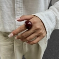 Macro shot of minimalist burgundy resin dome ring with a high-gloss polished finish - Ring / Red Brown