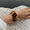 Detail of amber resin stretch bracelet featuring translucent pebble-shaped links on wrist - Resin Bracelet / Amber (2939)