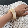 Detailed view of the marbled yellow resin wide bangle with smooth geometric textures - Beige (2252)