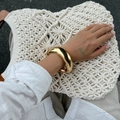 Close-up of wide polished gold metal bangle bracelet worn for a minimalist summer look - Metal Bangle / Gold (2431)